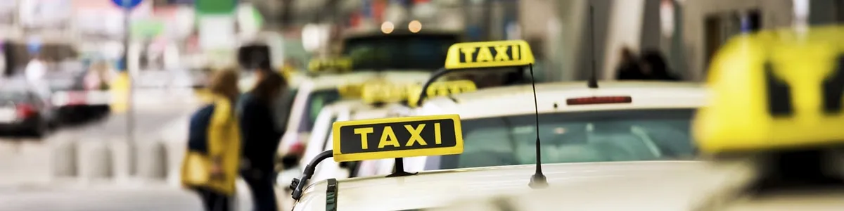 Taxis parken in einer Reihe, im Hintergrund stehen zwei Personen | Taxi Bischoff 